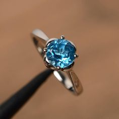 It is a real Swiss blue topaz  ring, round cut, measures 7mm*7mm, weight about 1.68 cts. The basic metal is sterling silver and plated with rhodium.To change the metal to a solid gold (white/rose) or platinum is also available, please ask for a quotation if you want.You can also go to my shop Home for more elegant rings: https://www.etsy.com/shop/godjewelry?ref=hdr_shop_menuSwiss blue topaz is birthstone of NovemberMore Swiss blue topaz rings:https://www.etsy.com/shop/godjewelry?ref=seller-platf Classic Round Topaz Crystal Ring, Classic Topaz Ring With Round Cut, Classic Round Cut Topaz Ring, Classic Round Topaz Birthstone Ring, Blue Topaz Solitaire Crystal Ring, Classic Sterling Silver Topaz Ring With Round Stone, Sterling Silver Solitaire Topaz Promise Ring, Sterling Silver Round Topaz Promise Ring, Classic Topaz Ring With Birthstone In Round Band