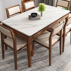 a dining room table with chairs and a vase on the top, in front of a window