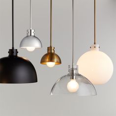 three pendant lights hanging from the ceiling in various colors and sizes, one with an oval glass shade