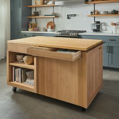 a kitchen island with an open drawer in the center and shelves on both sides that hold cookbooks