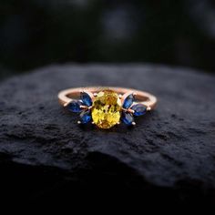 a yellow and blue ring sitting on top of a rock