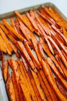 baked sweet potato wedges sitting on a baking sheet ready to be cooked in the oven