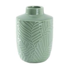 a light green vase with a leaf design on the front and bottom, sitting against a white background