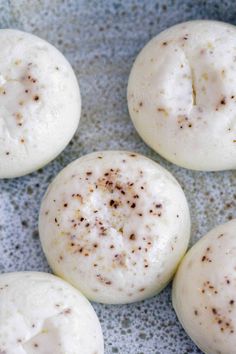 four white donuts with brown sprinkles on them