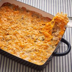 a cheesy casserole dish with a spoon in it