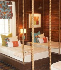 two twin beds in a room with wood paneling and white bedding, hanging from the ceiling