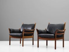 two black leather chairs sitting next to each other on top of a white flooring