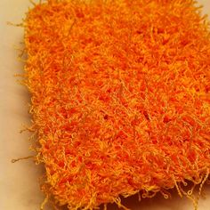 an orange piece of yarn sitting on top of a table