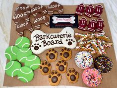 an assortment of decorated cookies and dog treats on a brown paper bag with the words barkcutie board