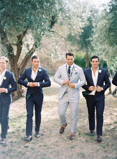 three men in suits and ties are walking together