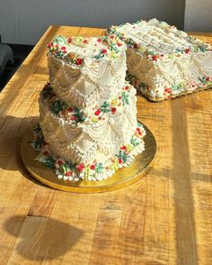 two wedding cakes sitting on top of a wooden table