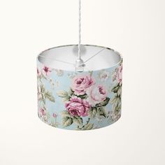 a blue flowered lamp shade hanging from a white ceiling with a string attached to it