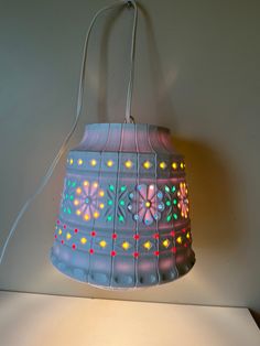 a lamp that is on top of a table next to a white wall and floor