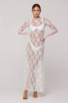 Discover elegance with the Lyon Lace Dress in White Lace. Crafted with a stunning white lace fabric and a high neck, this maxi dress. The sheer design adds an alluring touch, making it perfect for any vacation over our swimsuits. Elevate your style and embrace timeless beauty with this dress. This top is SHEER in our soft LACE fabric Maxi Length Lettuce Hem Neck and Wrist Detail Fabric: 95% Polyester 5% Spandex Model A is wearing a size XS Model A Measurements: Height 5'7, Waist: 25", Hips 32" B White Sheer Lace Dress, Sheer Lace Dress, White Lace Fabric, Transparent Dress, Lettuce Hem, Short Lace Dress, Grad Photos, White Swimsuit, Pretty Dress