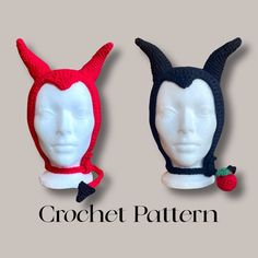 two crochet hats with horns and ears on top of each other, one has a strawberry in the middle