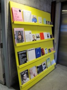 there is a yellow book shelf with many books on it