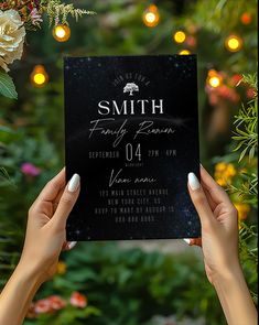 two hands holding up a black card with the name smith family reunion written on it