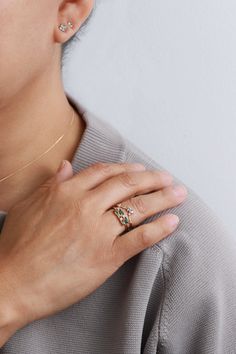 a woman wearing a gold ring with three diamonds