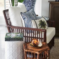 a wicker chair with pillows and a candle on it