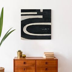 a black and white painting on the wall above a dresser