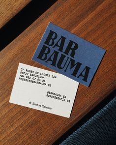 two business cards sitting on top of a wooden table