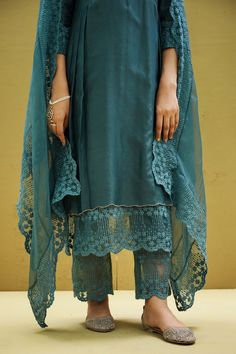 Yale blue kurta with delicate scallop trim on the neckline with pleats on both side. Paired with flower lace work pant and heavy embroidered dupatta.
Component: 3
Pattern: Embroidery
Type Of Work: Flower Embroidery
Neckline: Round Neck
Sleeve Type: Three Fourth Sleeves 
Fabric: Cotton, Chanderi, Organza 
Color: Blue
Other Details: 
Perwinkle embroidered sleeves
Handcrafted rose embroiderey on kurta
Note: Slip worn by the model is not for sale
Occasion: Mehendi and Haldi,Work - Aza Fashions Blue Flower Embroidery, Yale Blue, Embroidery Neckline, Blue Kurta, Kurta Set For Women, Cotton Flower, Embroidered Sleeves, Embroidery Cotton, Embroidered Dupatta