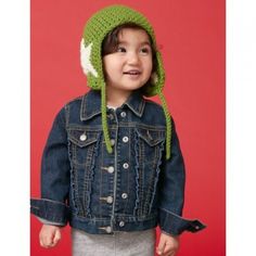 a young child wearing a knitted hat and denim jacket