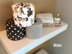 two cakes sitting on top of a white shelf in a bathroom next to other items