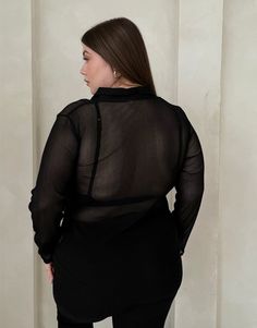 With its sleek and flattering silhouette, the Plus Size Sheer Ribbed Button Up Shirt offers a trending way update to your workwear wardrobe. Wear this plus size sheer top with a cute bralette underneath to give the full effect and a pair of trousers for a street style outfit that's very on trend right now. This top features buttons up the front, long sleeves, a v-shaped neckline, a folded-down collar, and a single chest pocket. The material is a sheer, stretchy knit material. This shirt is made Fitted Sheer Shirt For Work, Fitted Sheer Shirt For Workwear, Sheer Long Sleeve Office Top, Sheer Stretch Tops For Work, Sheer Button-up Tops For Workwear, Sheer Button-up Workwear Tops, Elegant Long Sleeve Tops With Built-in Bra, Sheer V-neck Blouse For Work, Sheer Collared Tops For Night Out