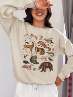 Woodland Animals Sweater, Retro Forestcore Fox Raccoon Academia Sweatshirt, Outdoors Mountains National Parks Shirt, Nature Lover Gift DETAILS ♥ Looking for a stylish and comfortable sweatshirt that celebrates nature's beauty? Our vintage design with woodland animals sweatshirt is the perfect choice! Featuring a classic design with adorable woodland creatures and made with soft and durable materials, this sweatshirt is perfect for any casual occasion. Whether you're hiking in the woods or loungi Animal Sweater, Nature Inspired Fashion, National Park Shirt, Animal Sweatshirt, Themed Outfits, Gifts For Nature Lovers, Woodland Animals, Sew-in Labels, Vintage Designs