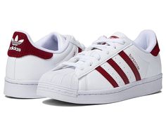 adidas Originals Kids Superstar (Big Kid) - Kids Shoes : White/Team College Burgundy/White : Showcasing a full-grain leather upper, retro rubber toe cap and iconic triple side-striping, these round-toe adidas Originals Kids Superstar sneakers are a chip off the ol' block. Throwback kicks feature an adjustable lace-up closure, breathable mesh lining, and an EVA midsole for lightweight cushioning. A herringbone-patterned rubber outsole keeps their feet on the ground. Imported. Measurements: Weight Synthetic Lace-up Skate Shoes With Three Stripes, Adidas Logo White Lace-up Sneakers, Adidas Lace-up Sneakers With White Sole, Adidas Low-top Synthetic Sneakers, High-top Synthetic Skate Shoes With Three Stripes, Red High-top Sneakers With Three Stripes, Adidas Logo Lace-up Synthetic Sneakers, Three Stripes High-top Sneakers For Sports, Sporty Adidas Logo Lace-up Sneakers