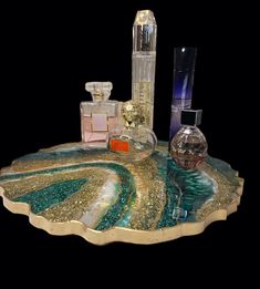 an assortment of perfumes are displayed on a glass tray with gold and blue designs