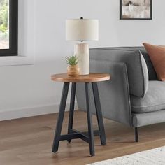 a living room with a gray couch and wooden table next to the sofa in front of it