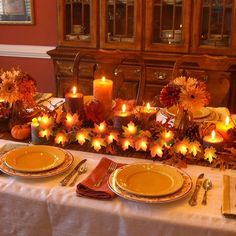 a table set for thanksgiving dinner with candles