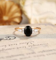 a black and white diamond ring sitting on top of a piece of paper