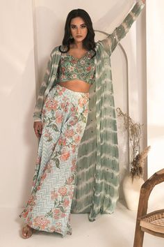 Blue tie dye pattern jacket with floral buttis and mirror work. Comes with floral embroidered blouse and chevron based, floral pattern sharara. - Aza Fashions Bohemian Palazzo Set With Zari Work, Bohemian Long Sleeve Lehenga For Festive Occasions, Bohemian Long Sleeve Fitted Anarkali Set, Spring Cutdana Set With Long Sleeves, Spring Long Sleeve Cutdana Sets, Spring Cutdana Long Sleeve Sets, Bohemian Long Sleeve Choli With Resham Embroidery, Spring Bollywood Choli With Dupatta, Bohemian Style Unstitched Blouse Set With Long Sleeves