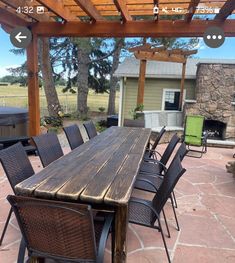 a wooden table sitting under a pergolated roof