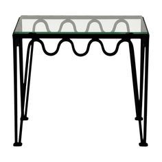 a glass and metal table with curved legs