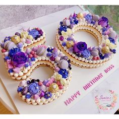 a birthday cake decorated with seashells and flowers on a white tray next to a card