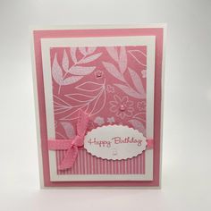 a pink and white birthday card with flowers on the front, ribbon around the edge