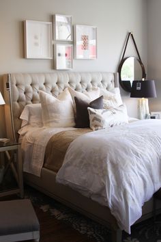 a bed with white sheets and pillows in a bedroom