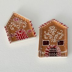 two gingerbread houses are decorated with candy canes