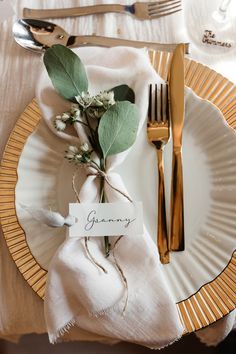 a place setting with silverware, napkins and flowers on the plate that says glammy