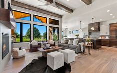 a living room filled with furniture and large windows