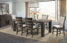 a dining room table with chairs and a vase on top of it in front of a window