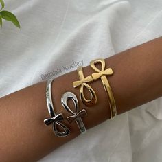 "Ankh Bangle - Gold/Silver The Ankh or also known as The Key of Life is an ancient Egyptian symbol that dates back to the early dynastic period. The first \"cross\". It symbolises life and is originally based on the feminine principals of nature, spirituality and peace. The most sacred symbol of ancient Egypt. It is an amulet for spiritual healing. Also worn for goodluck and to protect against bad energies 🖤 Fits any size arms. Open the two ankhs and place wrist in between for easy access. Made from copper and silver/gold plated. (click this link for tips on how to maintain your jewellery for as long as possible Www.Damilolajewellery.co.uk/pages/jewellery-care)" Silver Cross Bracelet, Spiritual Style, Spiritual Silver Cross Bracelet, Silver Cross Jewelry For Ceremonial Occasions, Ceremonial Silver Cross Jewelry, Nature Spirituality, Key Of Life, Ancient Egyptian Symbols, Bangle Gold, Egyptian Symbols