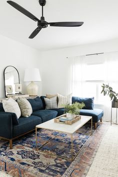 a living room with blue couches and rugs on the floor in front of a window