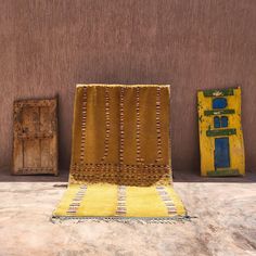 a yellow chair sitting in front of a brown wall