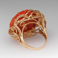 This fantastic vintage ring is centered with a carved floral design coral that is set into four-prongs. The coral is bordered with four (4) prong set round brilliant cut diamonds. The ring measures 25.9mm at the top, rises 12.7mm above the finger, tapering to 2.5mm wide and 0.8mm thick at the base of the shank. It is currently a size 4.5. Luxury Coral Engagement Rings, Luxury Carved Orange Jewelry, Luxury Elegant Coral Rings, Luxury Coral Gemstone Ring, Coral Ring, The Coral, February Birth Stone, Vintage Ring, Amethyst Ring