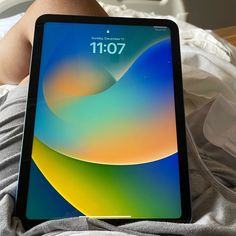 a person laying in bed with an ipad